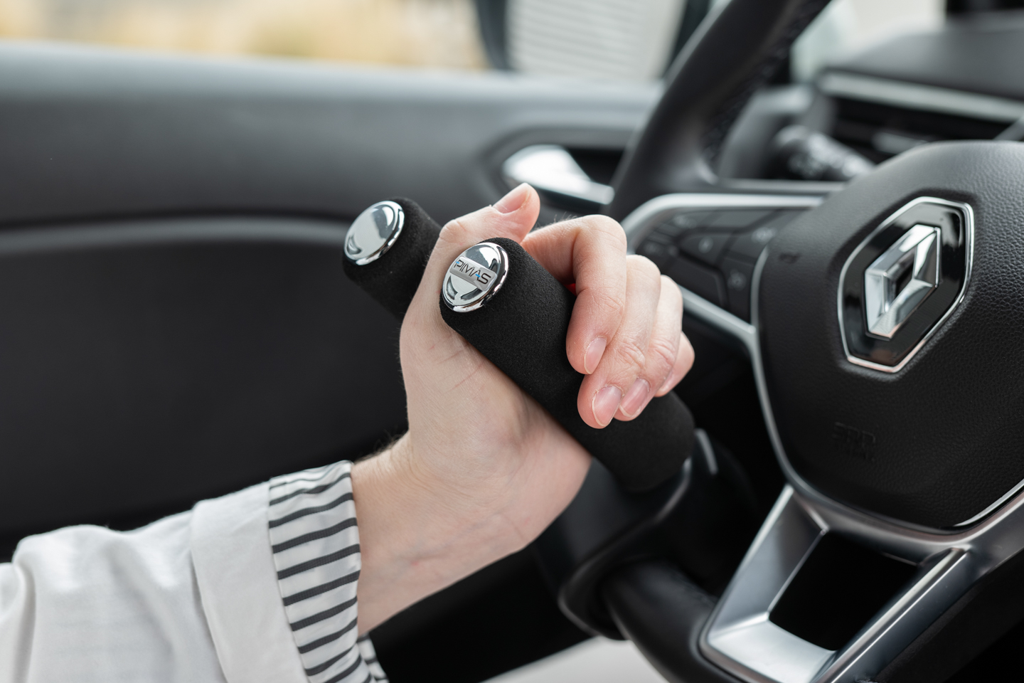 Boule au volant noire installée sur un volant, aide à la conduite pour personnes à mobilité réduite.