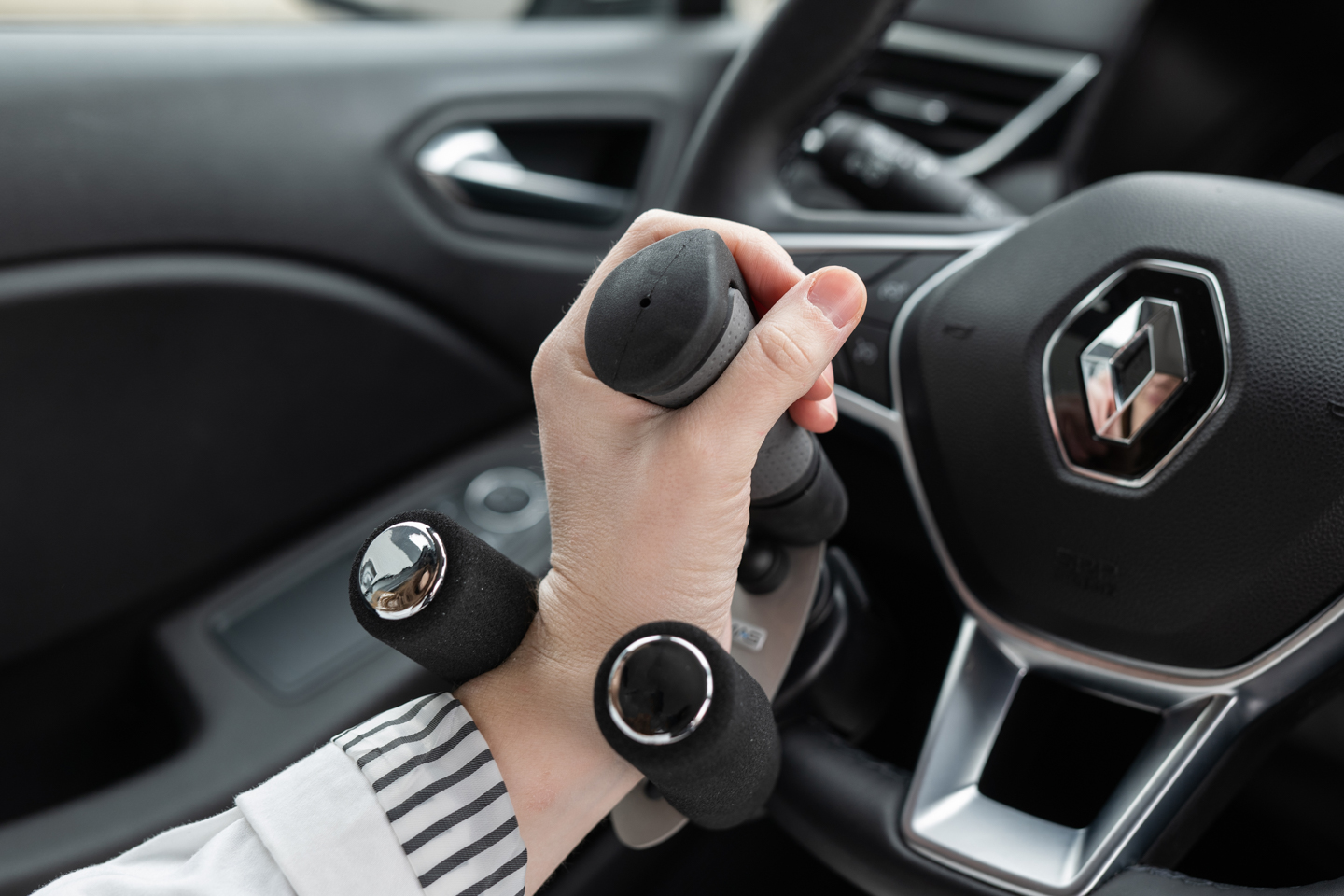 Boule au volant noire installée sur un volant, aide à la conduite pour personnes à mobilité réduite.