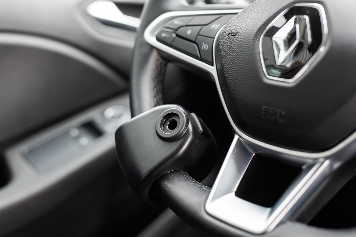 Boule au volant noire installée sur un volant, aide à la conduite pour personnes à mobilité réduite.