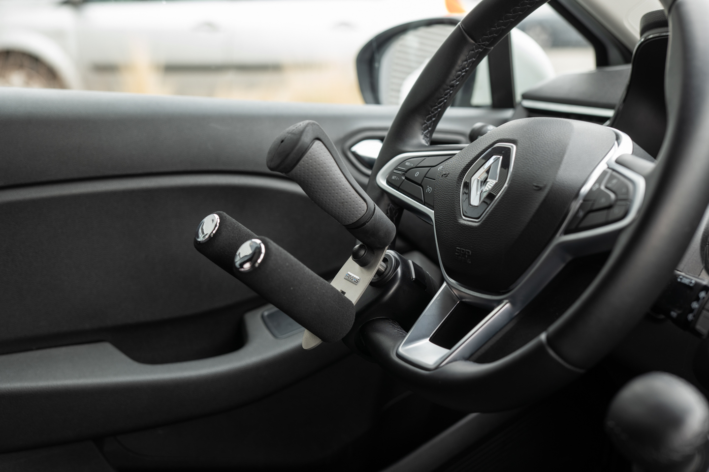 Boule au volant noire installée sur un volant, aide à la conduite pour personnes à mobilité réduite.
